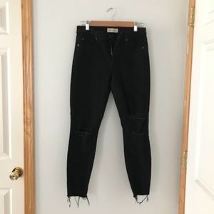 Distressed black denim with raw hem